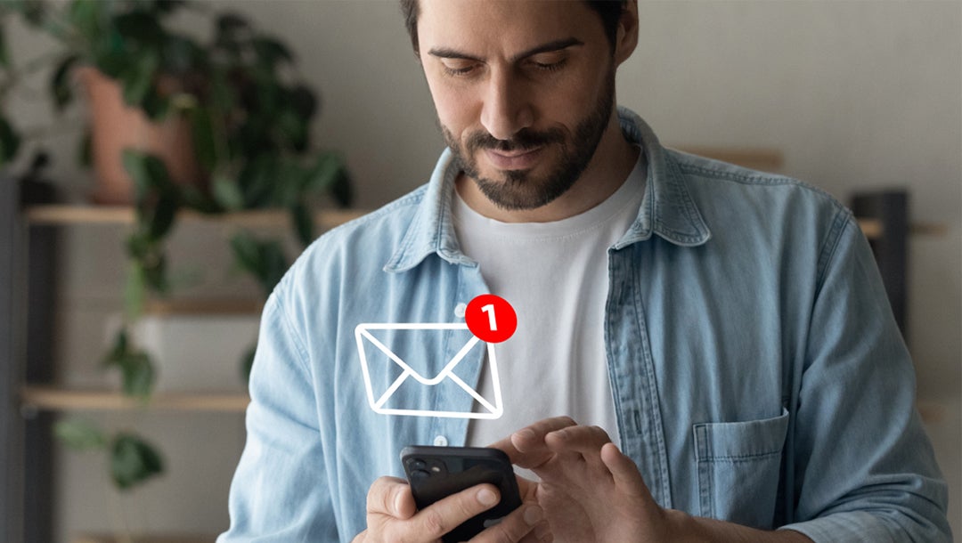 Mann mit Smartphone und eingeblendetem E-Mail-Icon als Symbol für digitale Kommunikation.