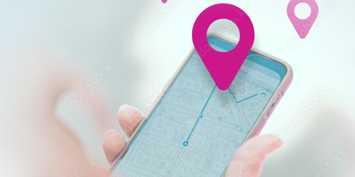Smartphone mit Navigations-App in der Hand, digitale Kartenansicht mit Standort-Pin und Routenführung auf dem Display